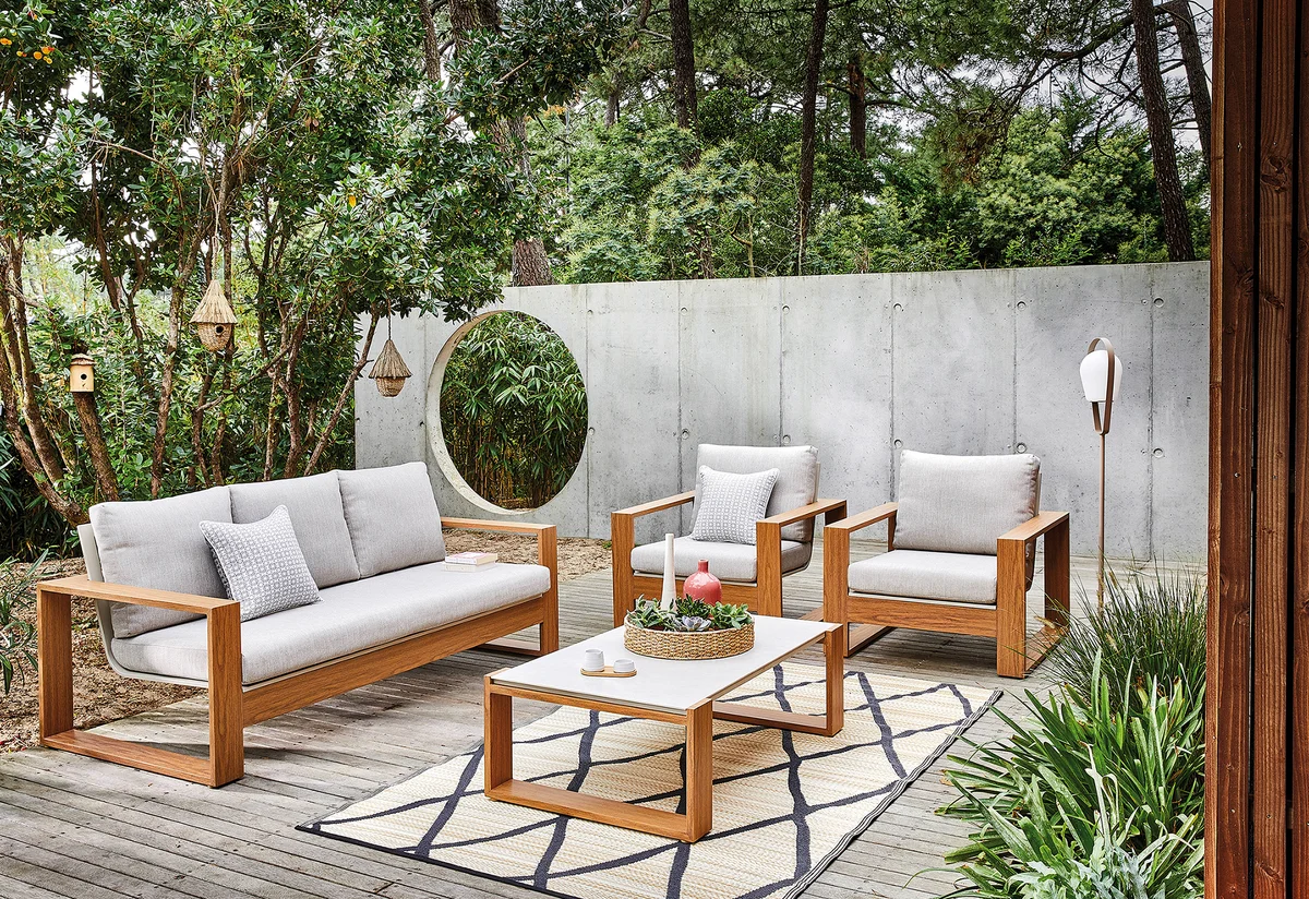 Ensemble détente Laser Proloisirs - canapé et 2 fauteuils finition imitation bois avec coussins gris clair et table basse sur terrasse en bois