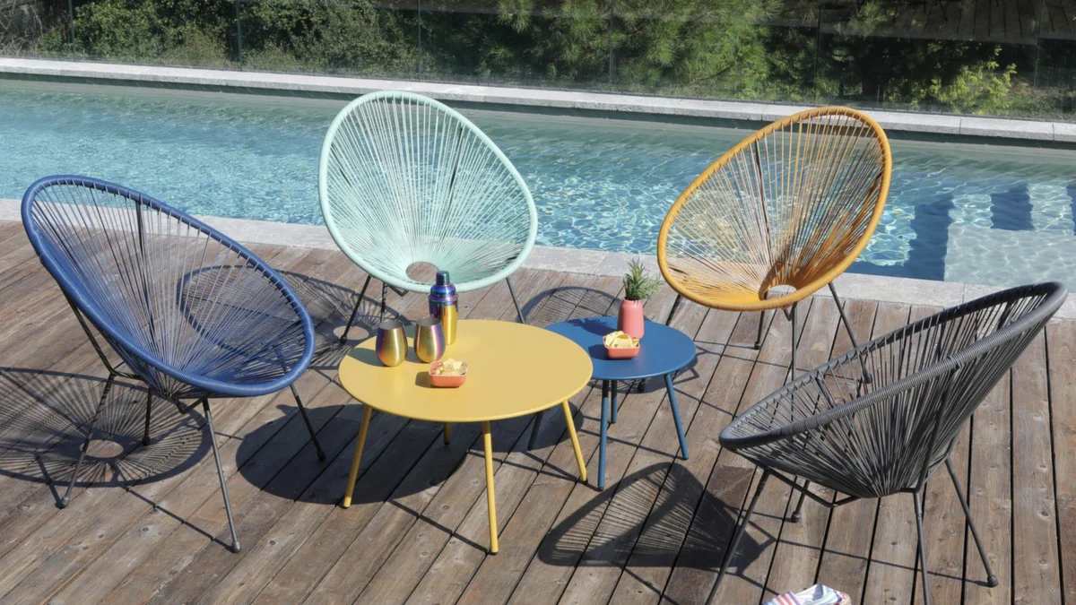 Tables basses Massaï Proloisirs colorées avec fauteuils Smiley dans un jardin ensoleillé